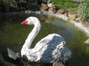 Лебедь сделанный из монтажной пены в пруду